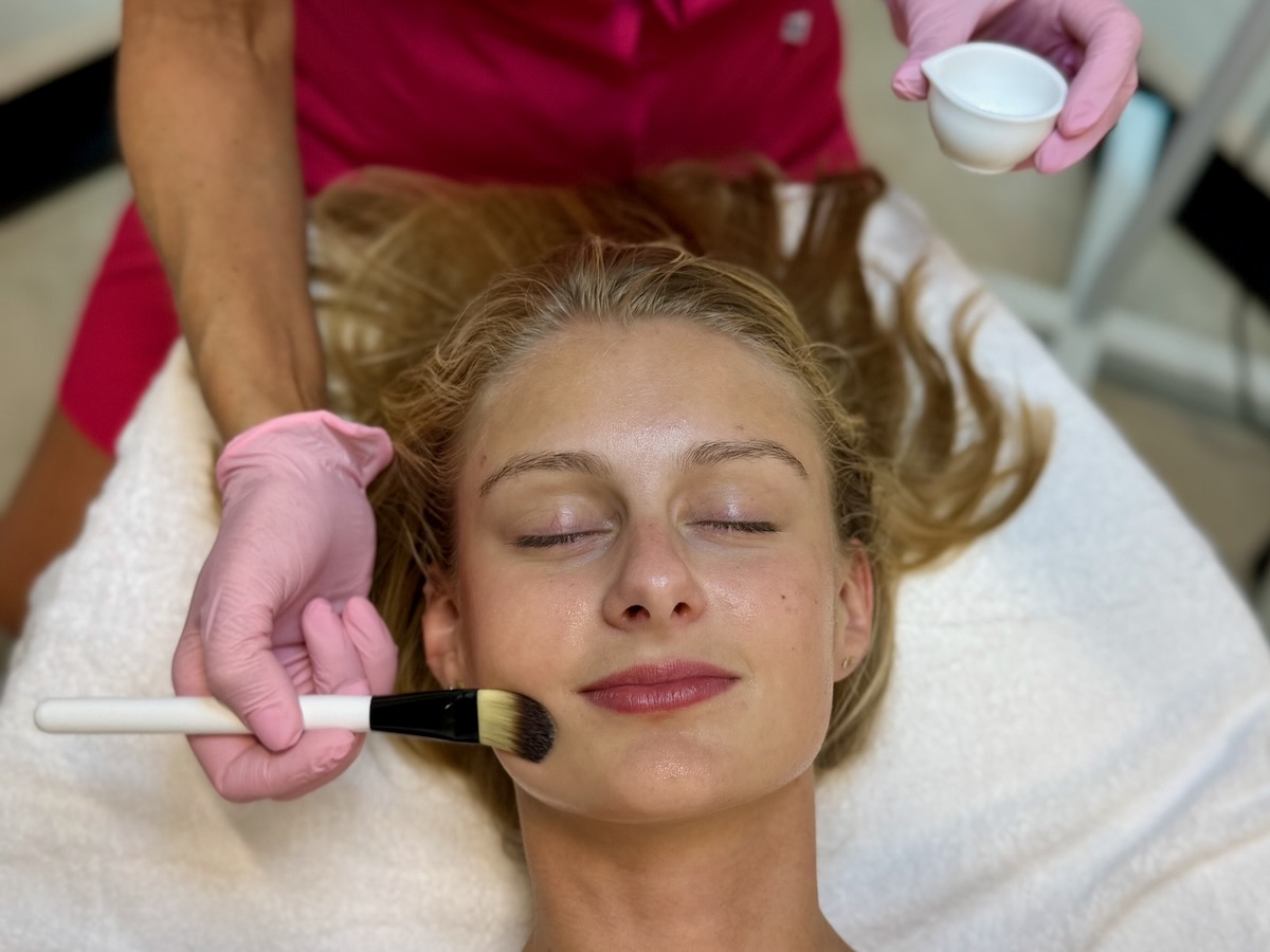 Aplikacja peelingu pędzelkiem podczas zabiegu na twarz